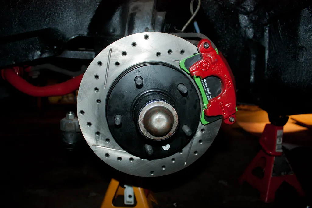 Disco de freno perforado con pinza roja montado en el buje